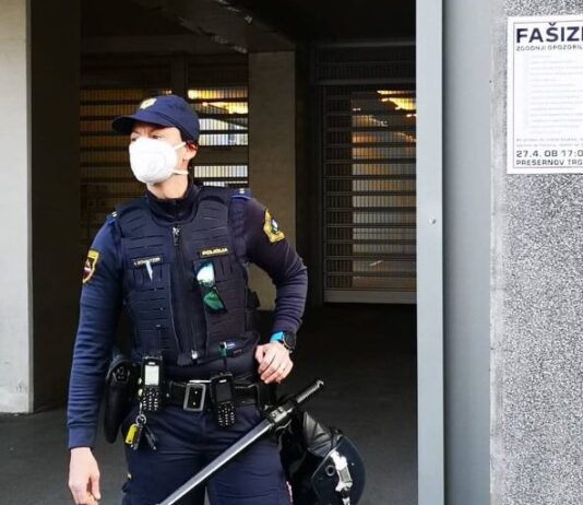 Propagandni letak anarholevičarjev pred poslopjem vlade lastnoročno odstranila policistka